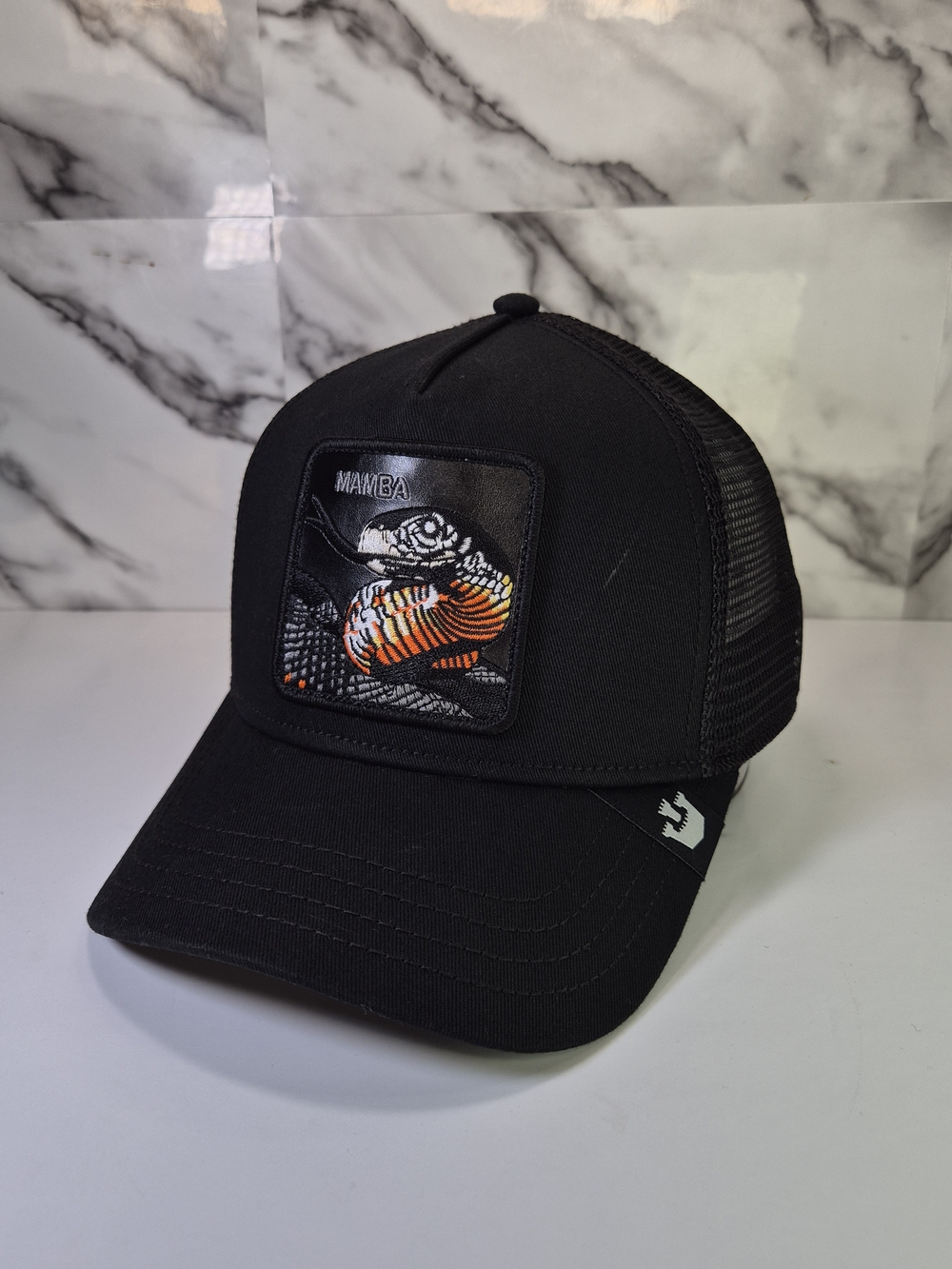 The Farm Goodin Bros. Mamba Black Trucker Hat with Orange Accent. Leather Patch